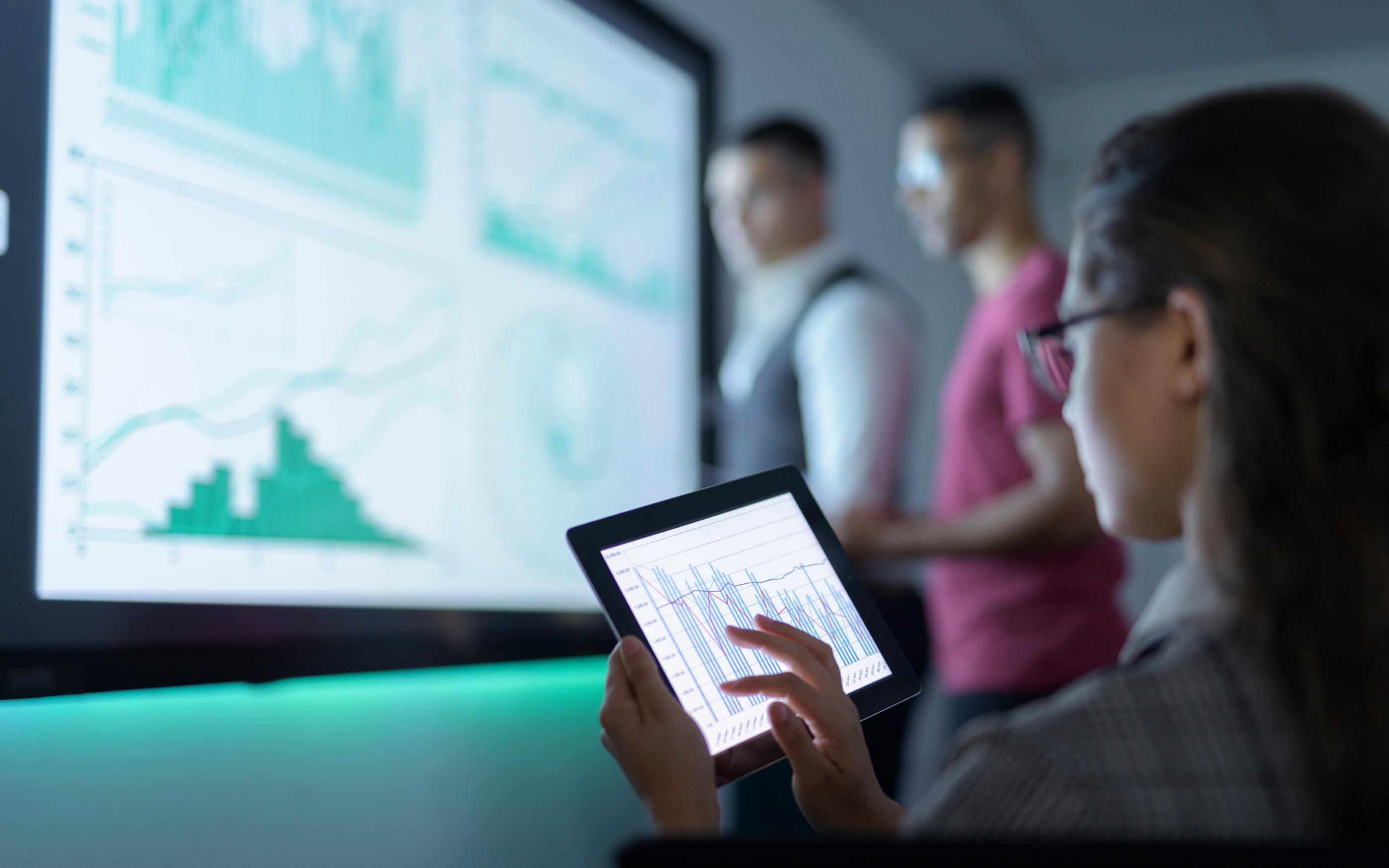 Businesswoman viewing graphs on digital tablet in business meeting