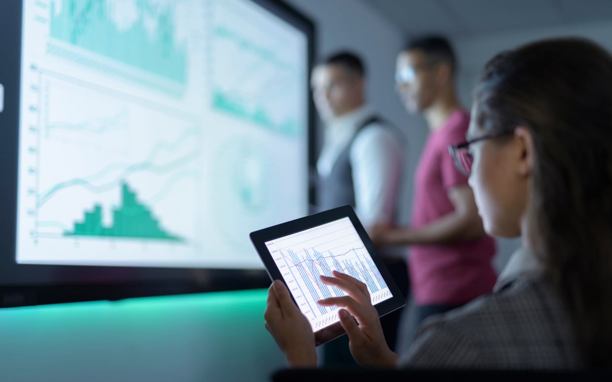 Businesswoman viewing graphs on digital tablet in business meeting