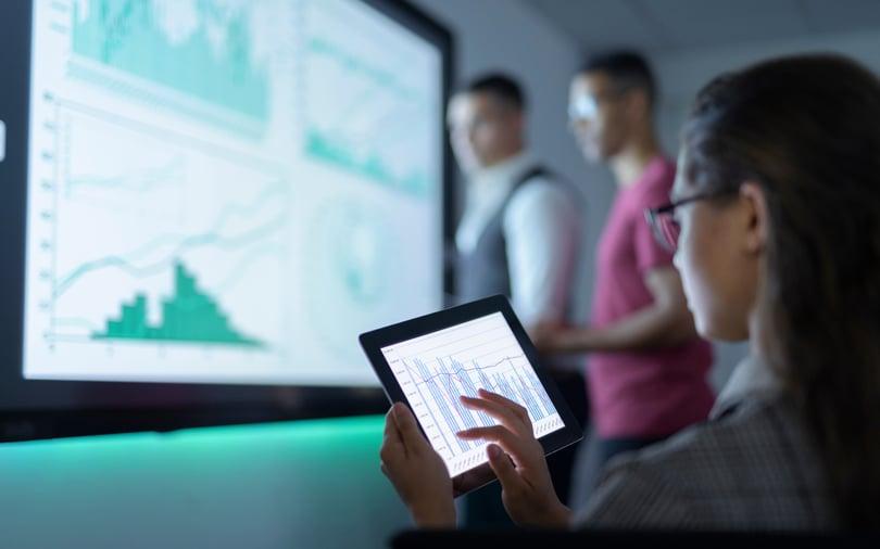 Businesswoman viewing graphs on digital tablet in business meeting