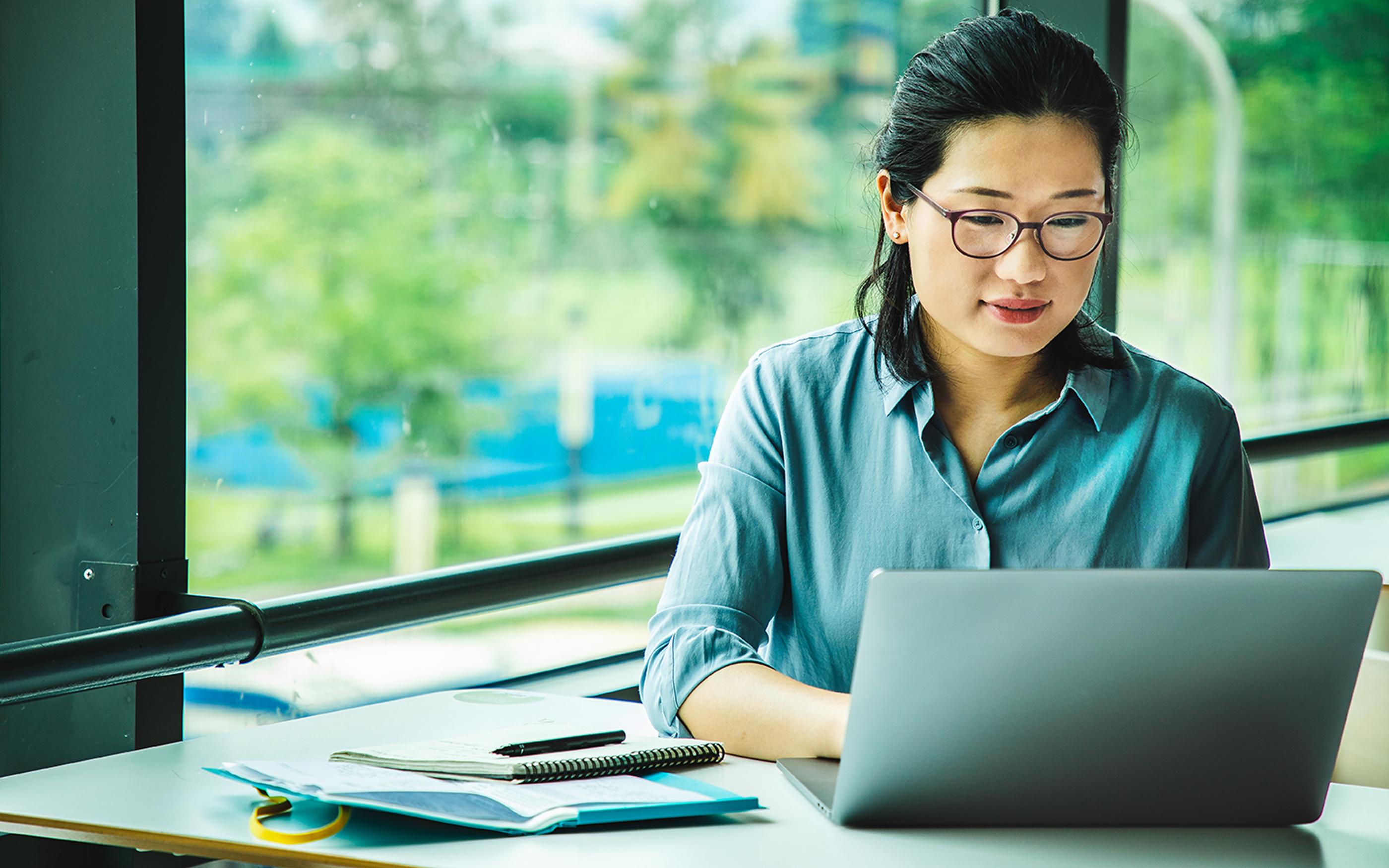 Asian woman working on a laptop remotely