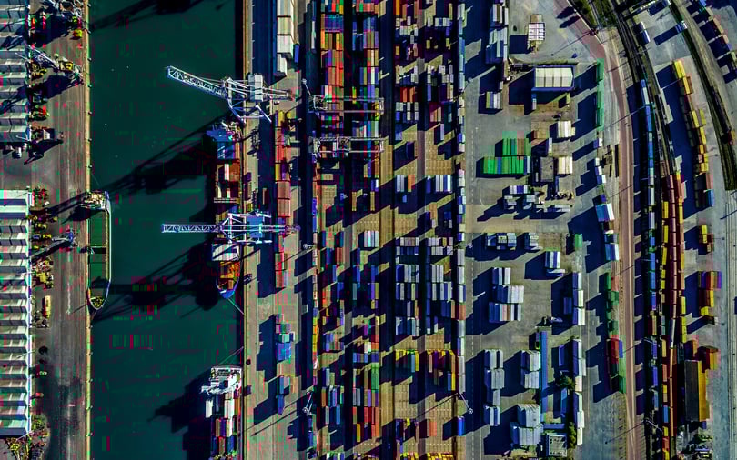 Bird's eye view of a crowded shipping terminal with organized rows of colorful cargo containers.