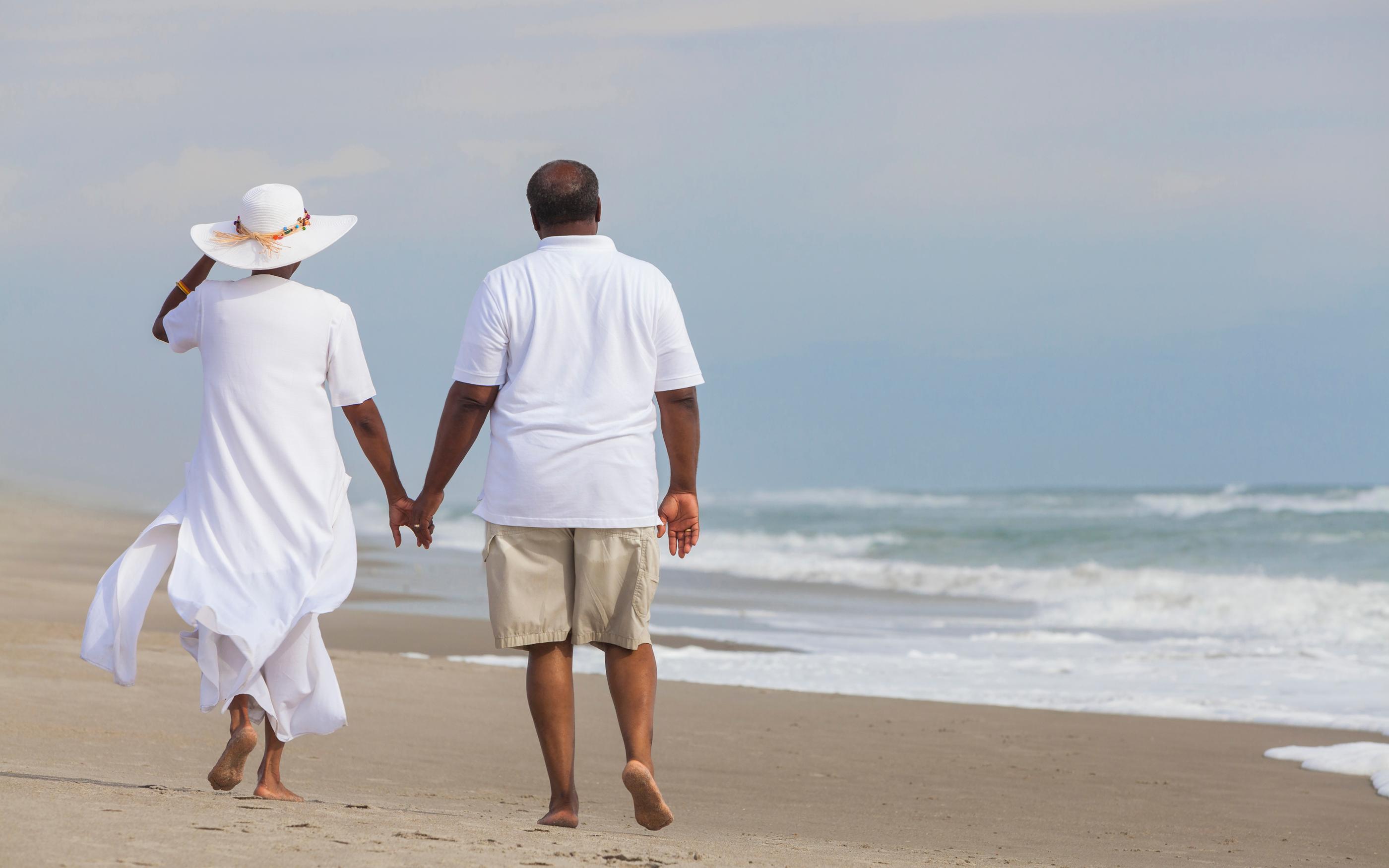 Man and woman holding hands on the beach