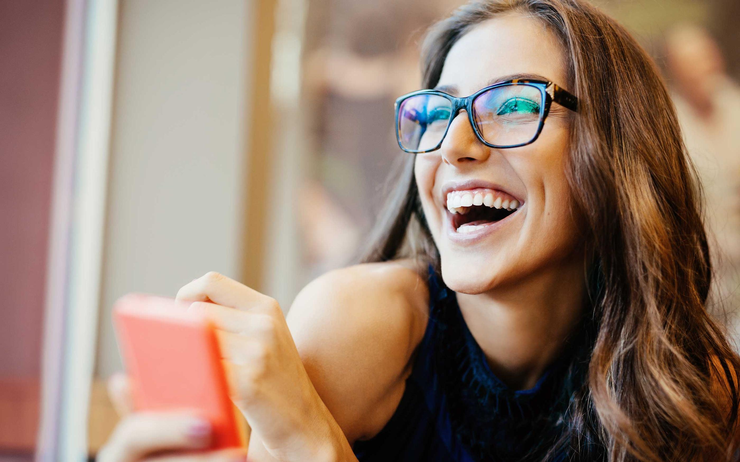 Woman smiling holding her mobile phone