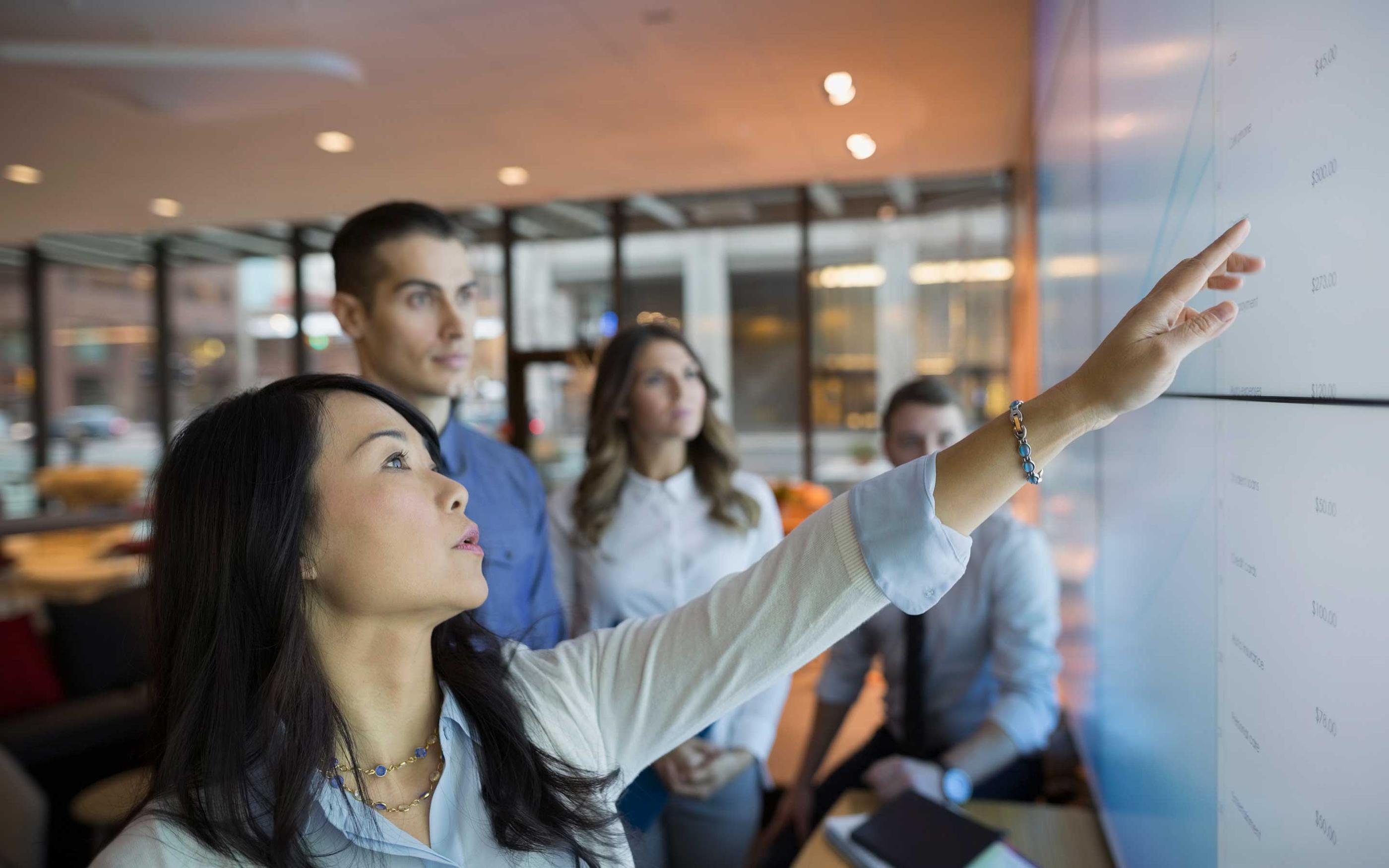 Business people pointing at projection screen conference room