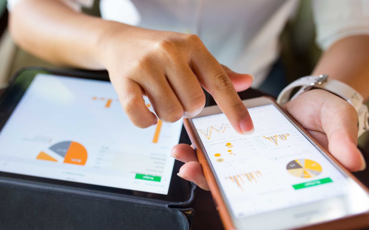 Woman looking at a graph with phone in hand