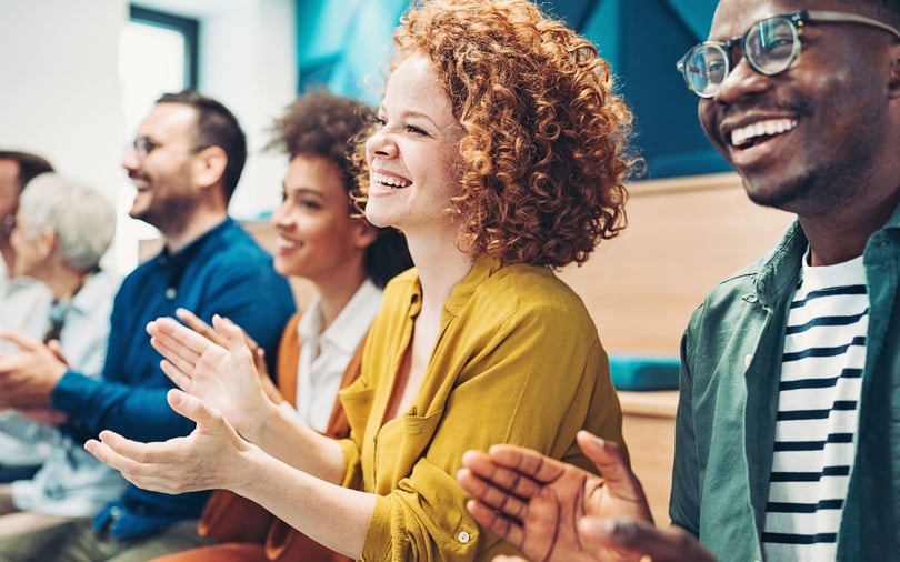 Happy people in an audience applauding