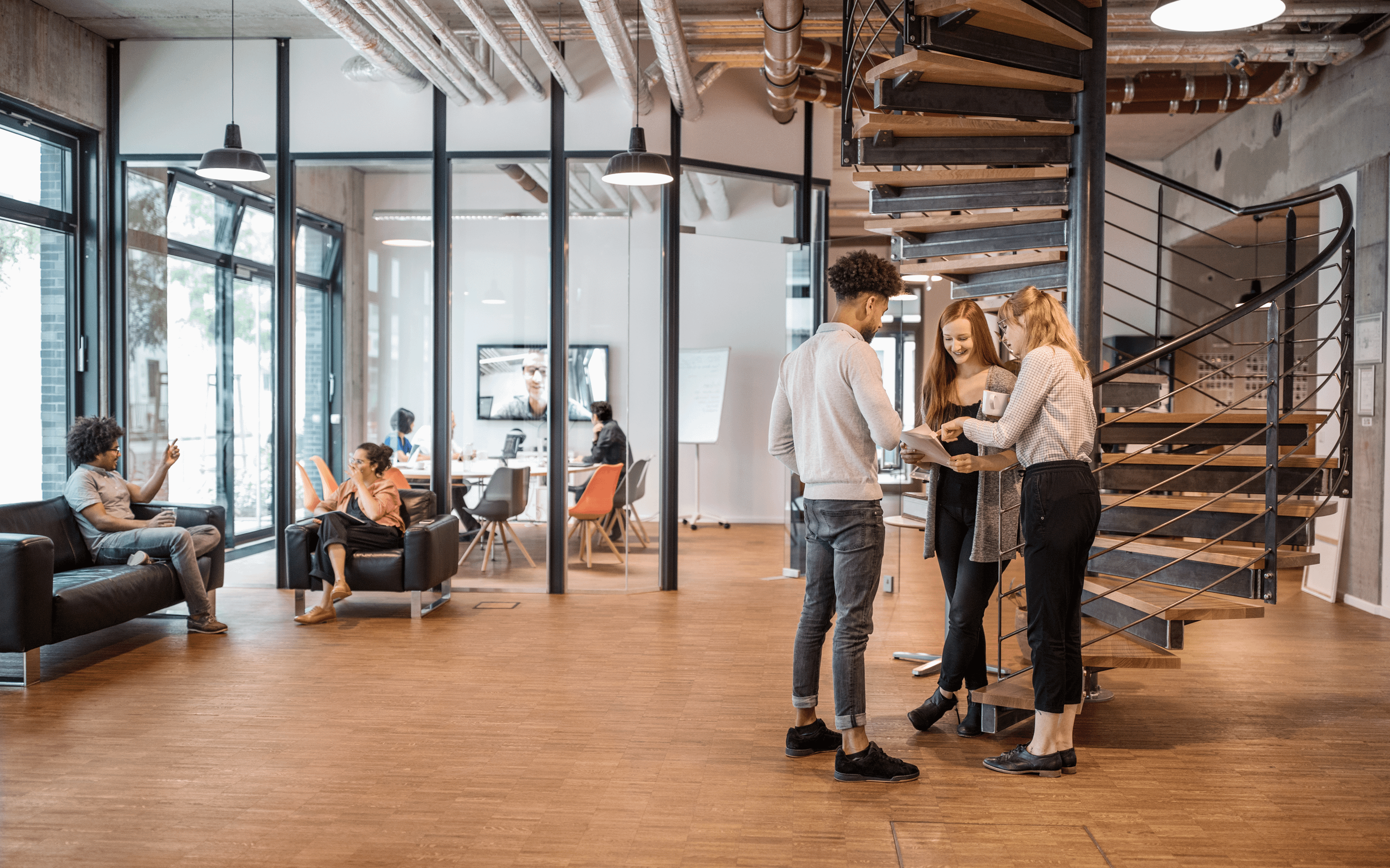 Three business people having a standing discussion in an open office 